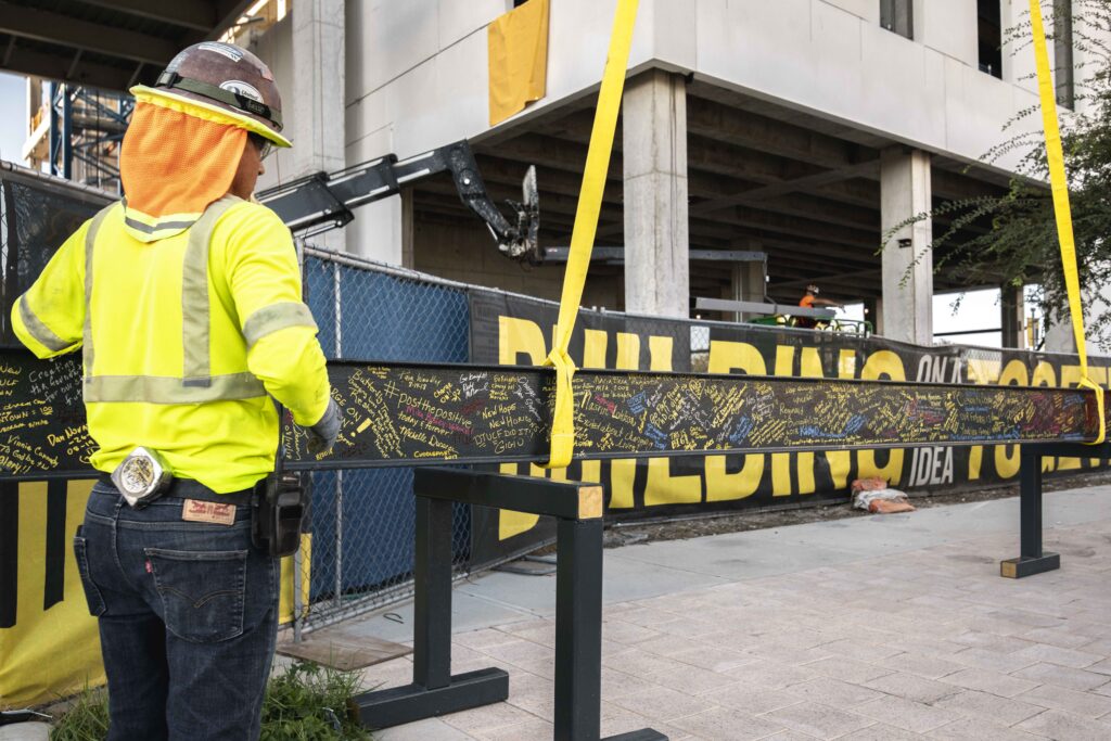 Construction workers puts up banner at work site